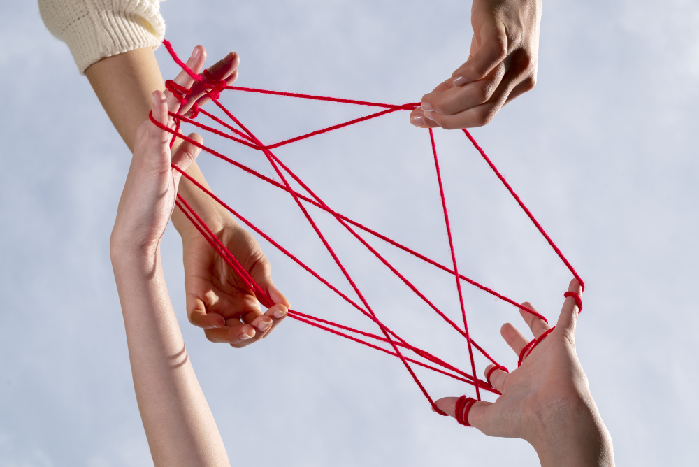 human hands connected with red thread